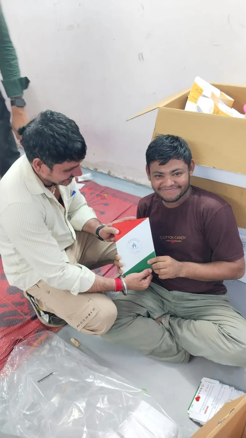 A worker smiling as he receives the Workers of India booklet