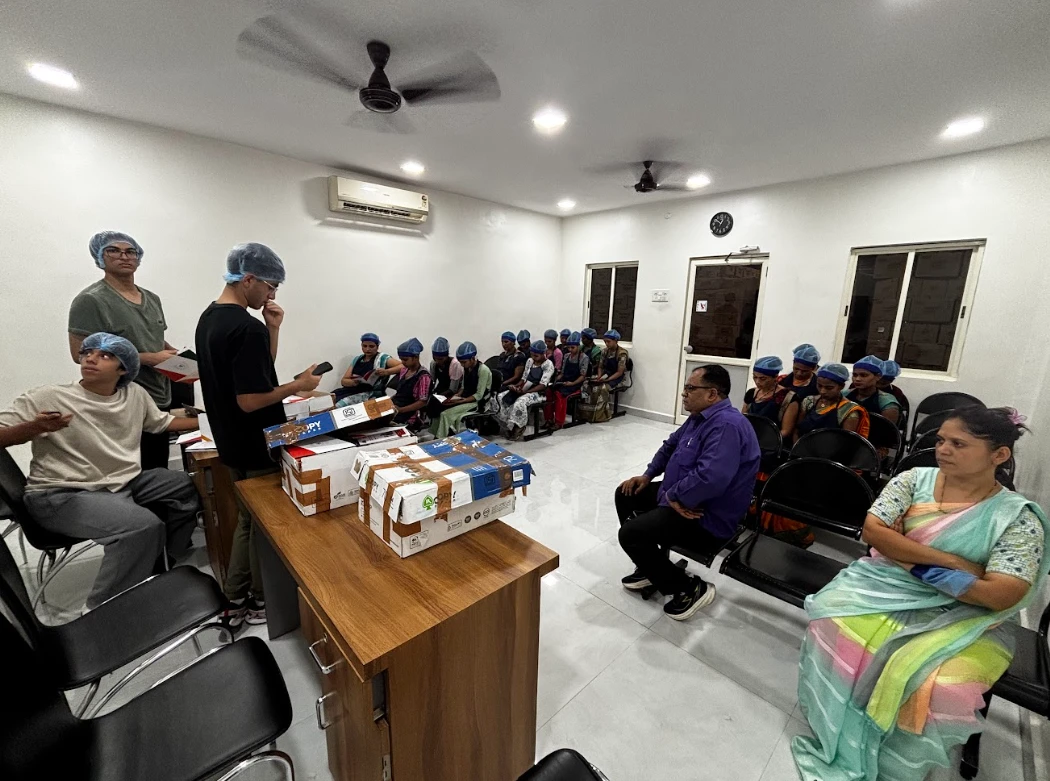 Factory workers holding the Workers of India booklet during the session