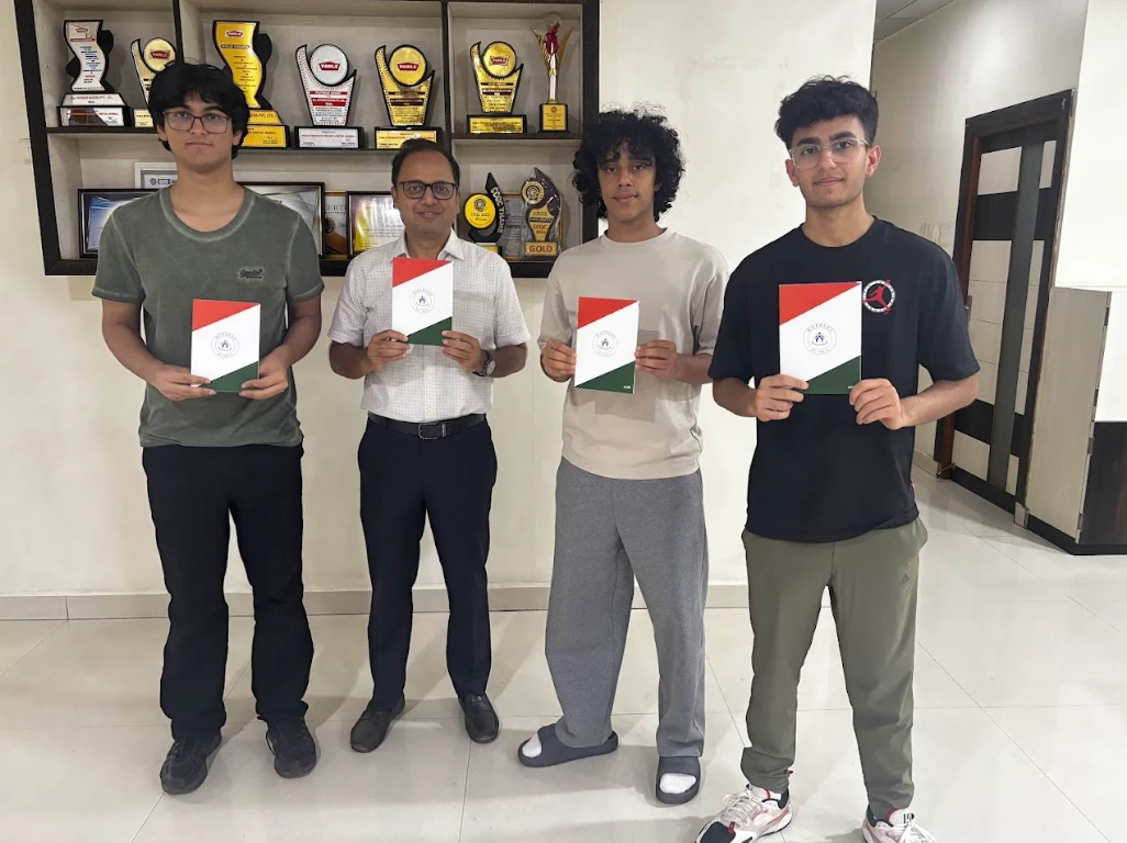 The Workers of India volunteer team with factory management holding the booklet
